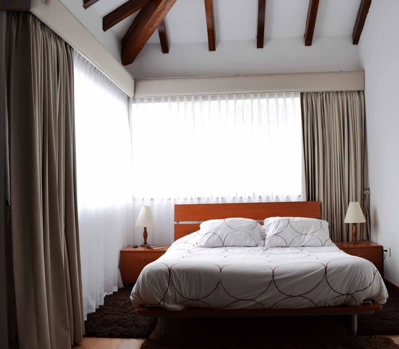 Habitación con cortinas y visillo instalados por DekoClass